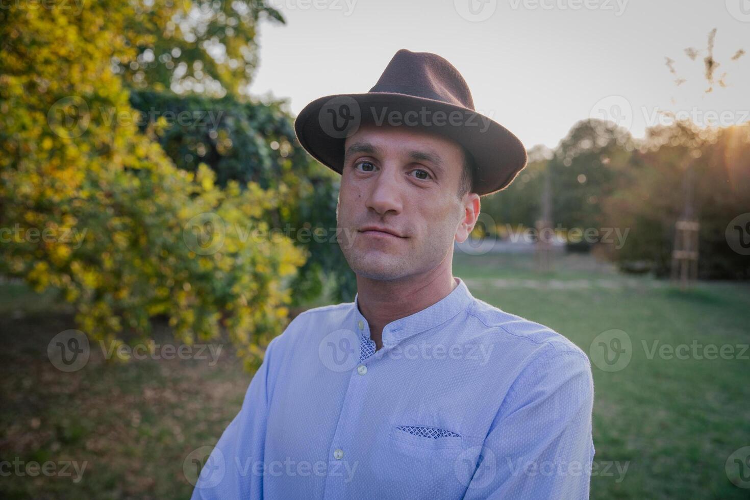 Portrait of a relaxed man wearing a hat outdoor at a public park, carefree person photo