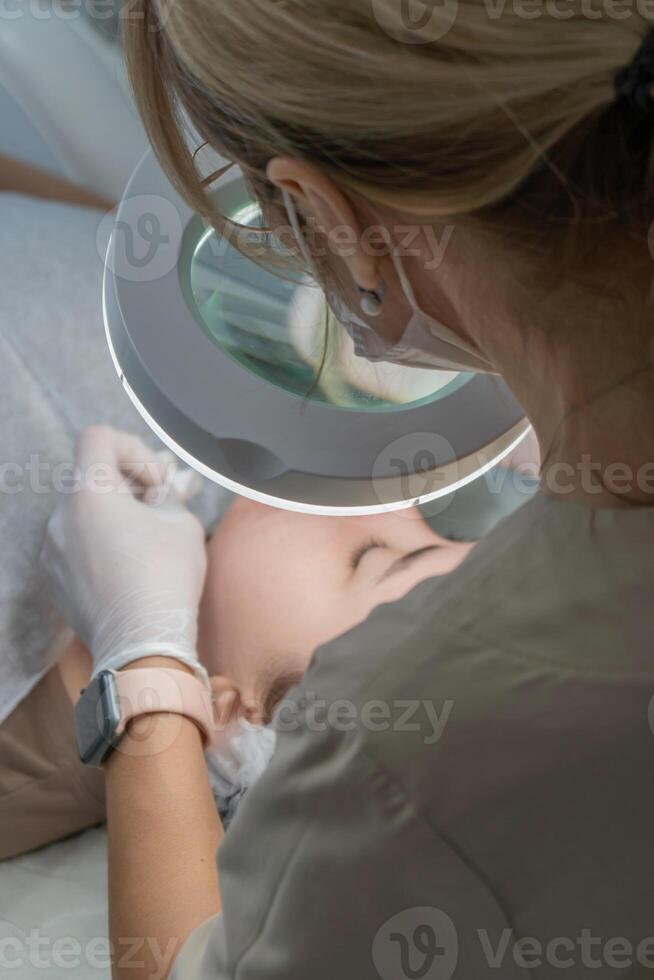Infant Ear Examination Clinic Healthcare. Doctor examining baby's ear using magnifying glass during checkup. photo