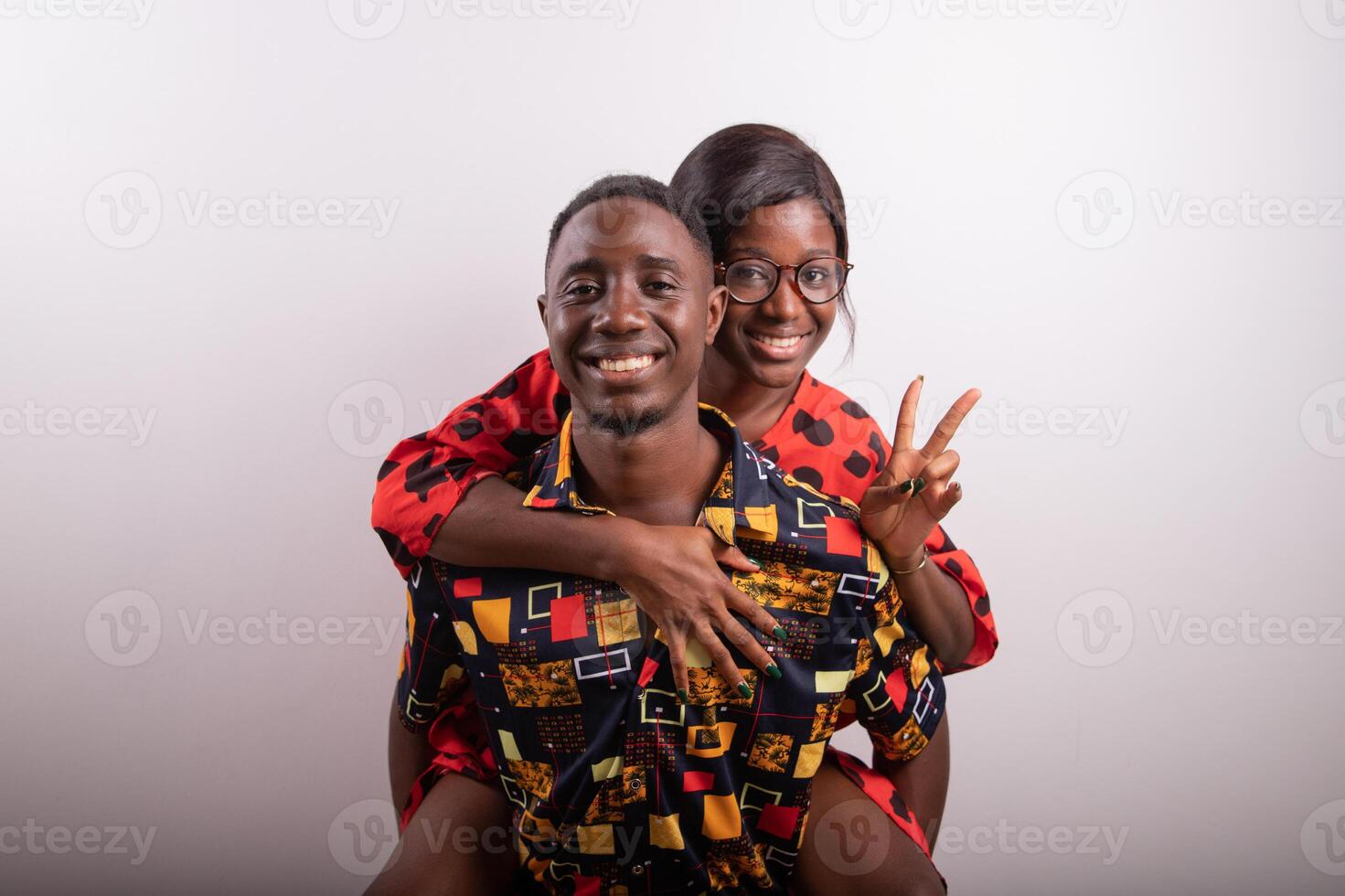 Girlfriend on the back of their boyfriend pose for a photo in the studio together, happy and in love couple.