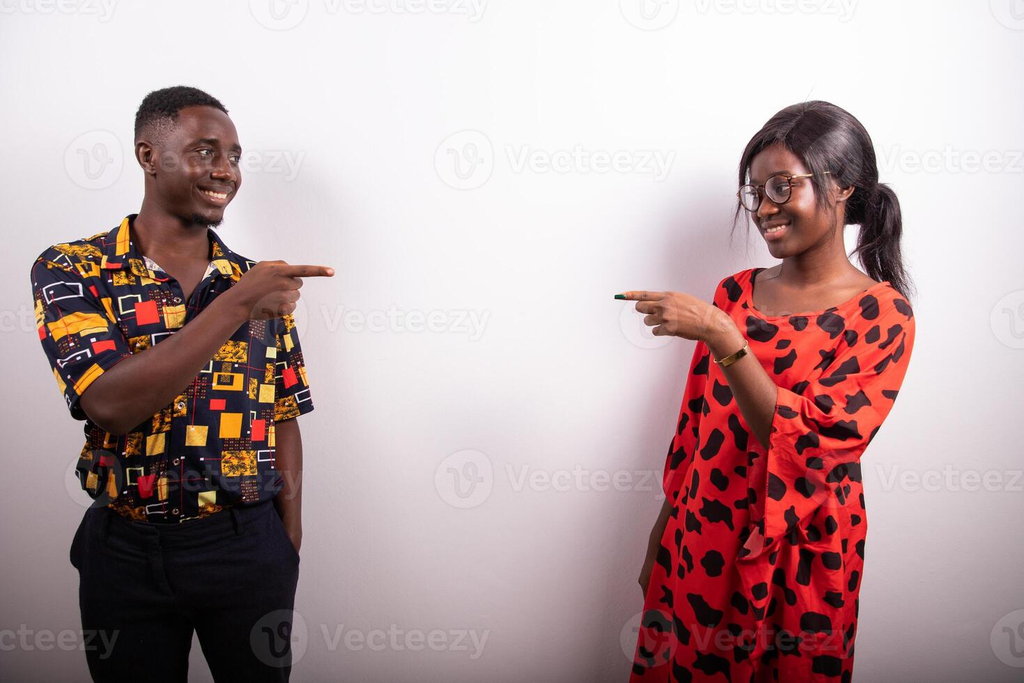 The guys, one on the left and the other on the right point with their index fingers to something invisible in the middle photo