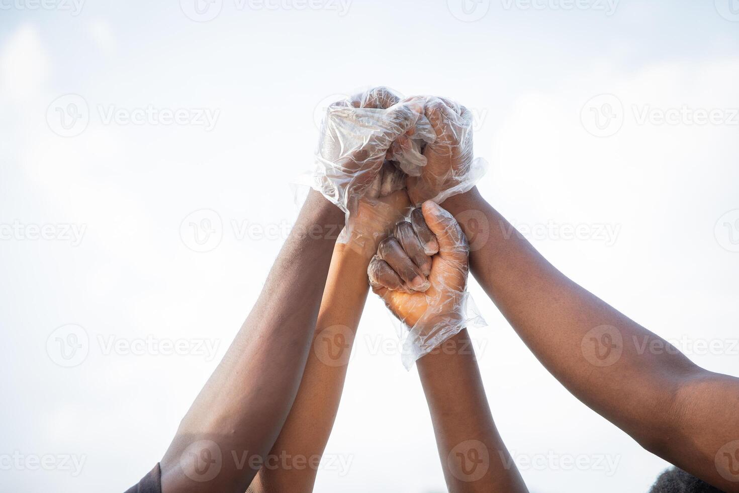 Four fists of African people are raised to the sky and join together in protest. photo