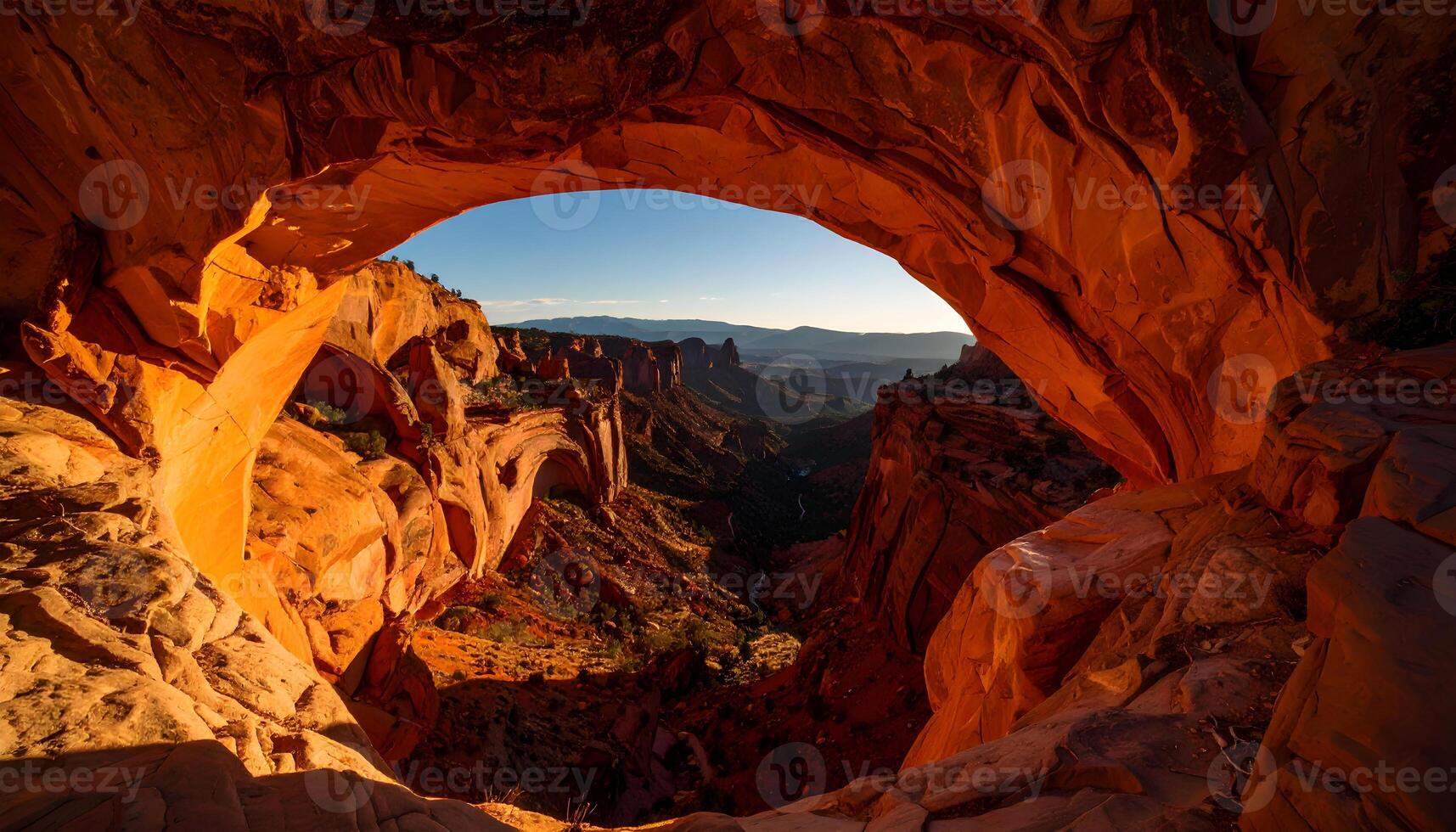 Majestic canyon landscape viewed from red rock arch at sunrise photo