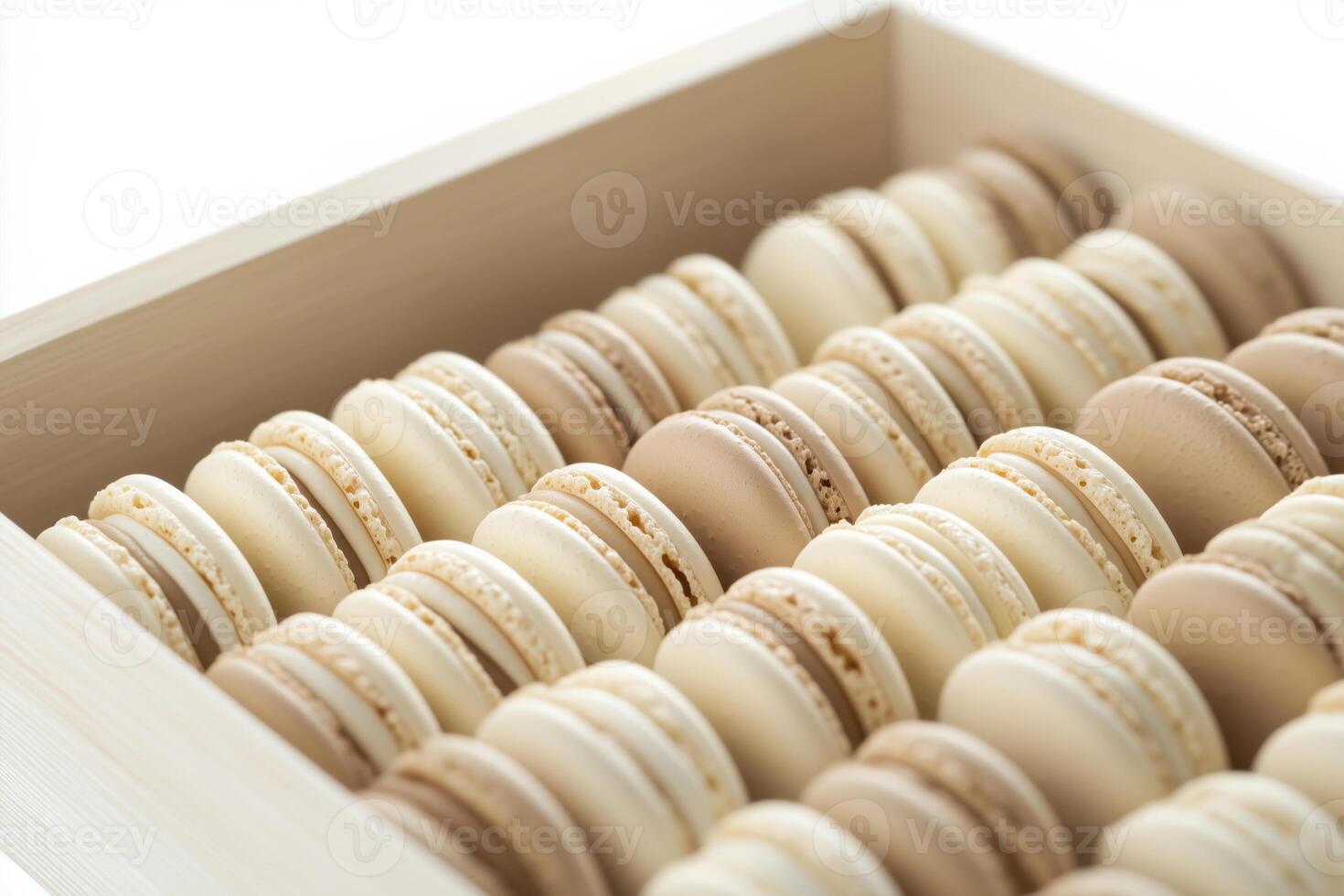 Assortment of beige and cream-colored French macarons arranged in rows inside a box photo