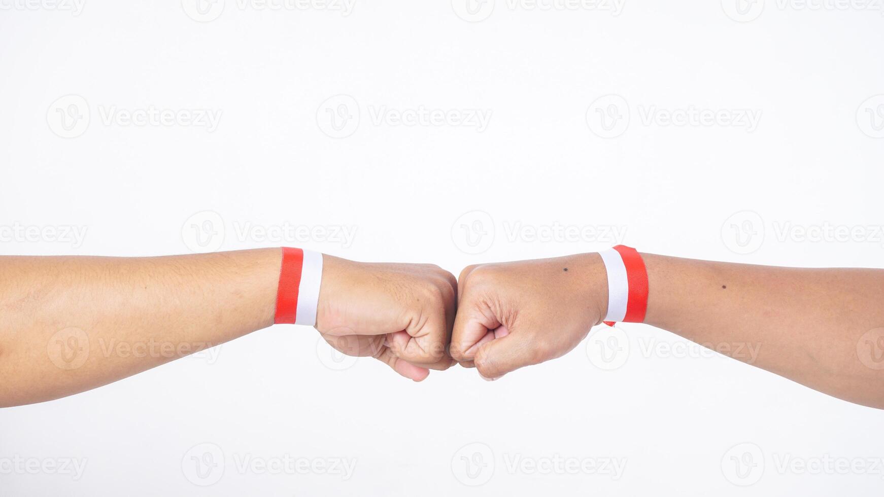 Two men with red and white wristband doing fist bump isolated on white background photo