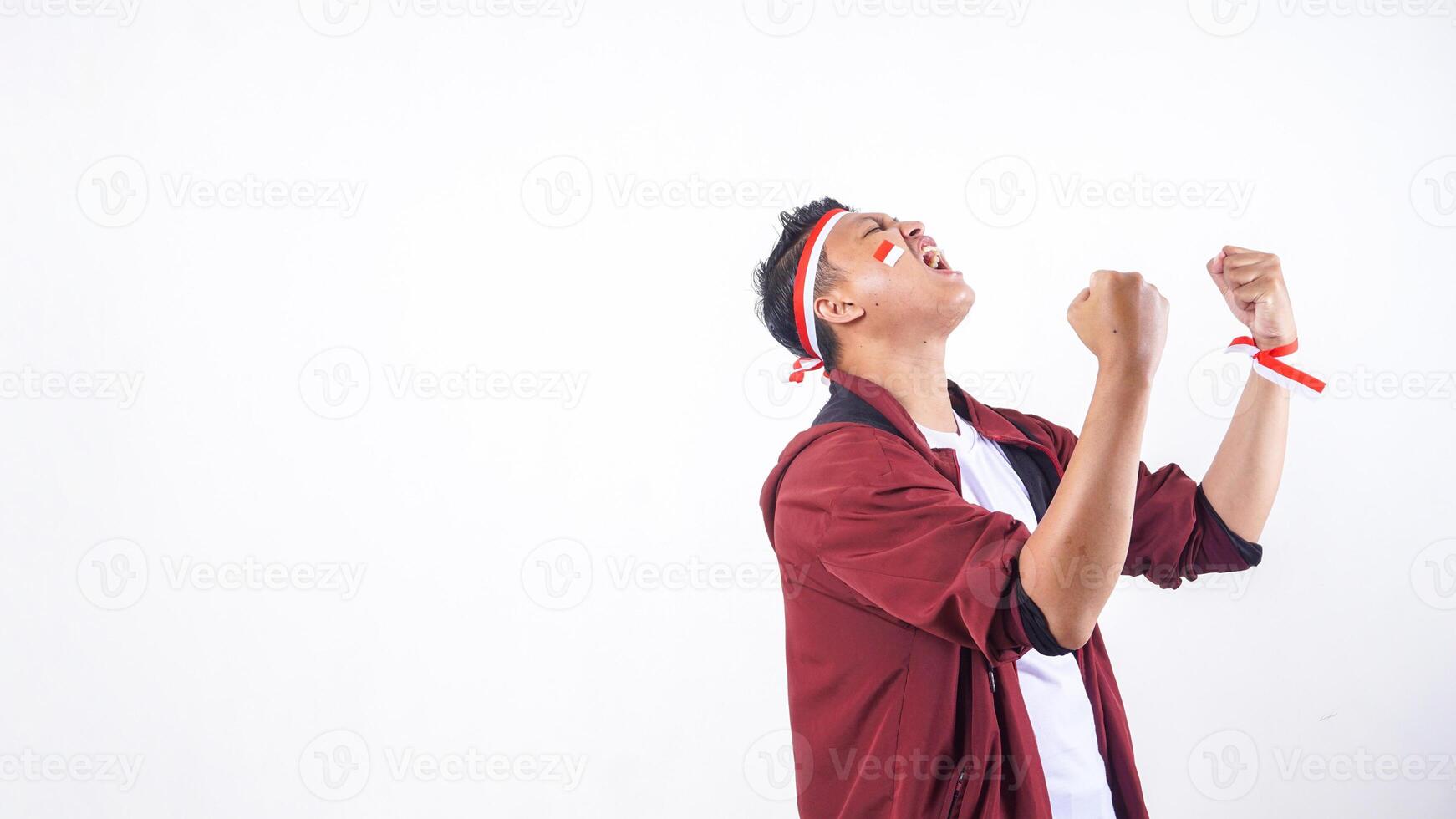 Grateful Indonesian man with red and white ribbon wristband to celebrate independence day of Indonesia isolated on white background photo