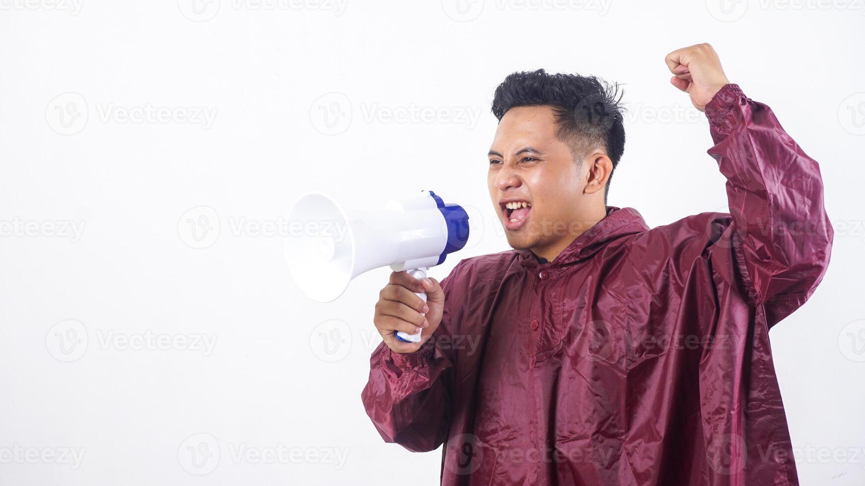 Asian man in red raincoat shout using megaphone with spirit isolated on white background photo