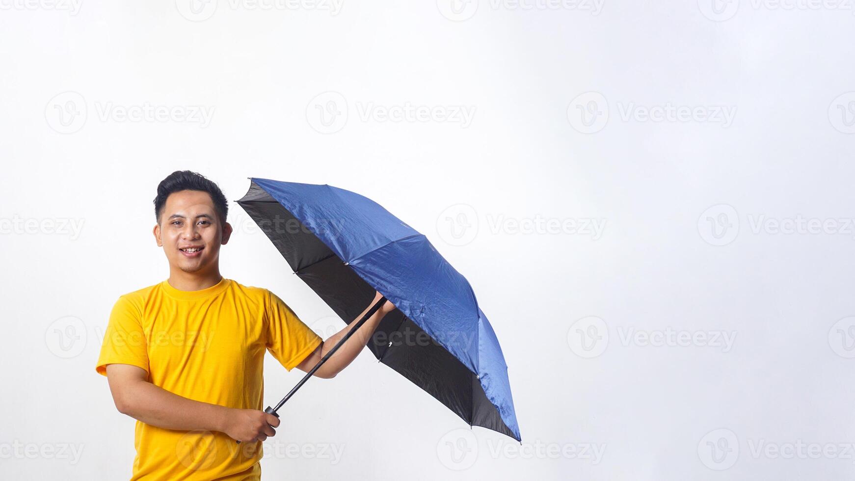Smiling Asian man holding an umbrella isolated on white background photo