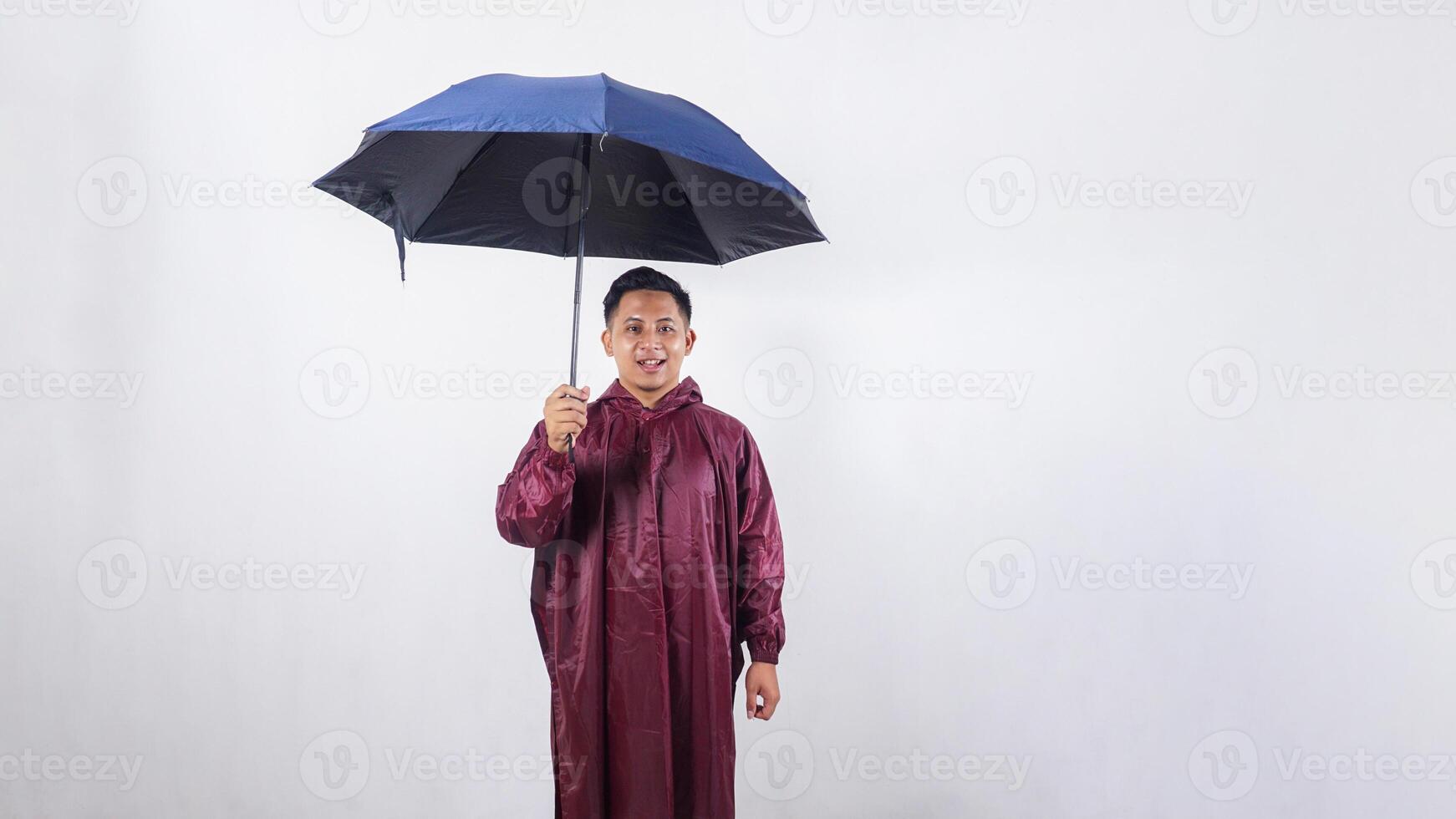 Smiling Asian man in red raincoat with umbrella isolated on white background photo