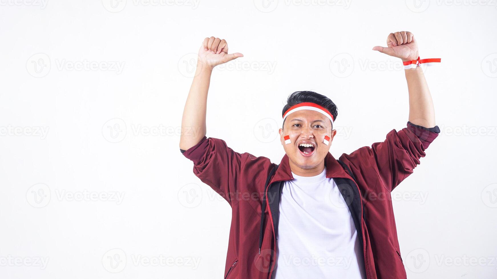 Happy pose of Indonesian man with red and white ribbon wristband to celebrate independence day of Indonesia isolated on white background photo