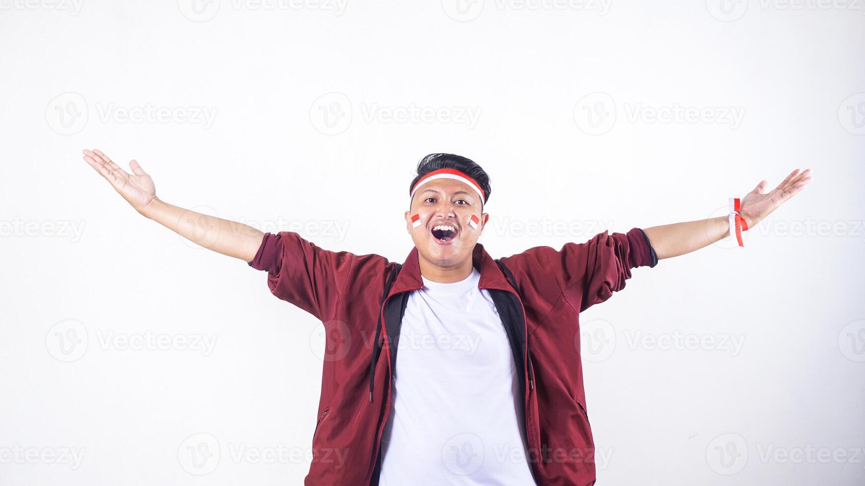 Happy Indonesian man with red and white ribbon wristband to celebrate independence day of Indonesia isolated on white background with copy space photo