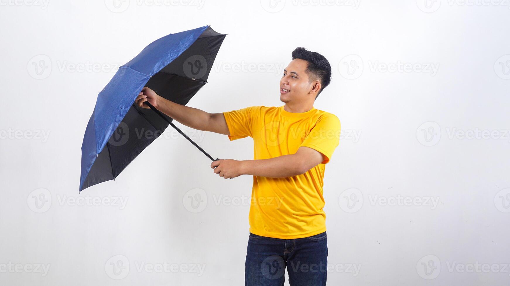 Smiling Asian man holds blue umbrella isolated on white background photo