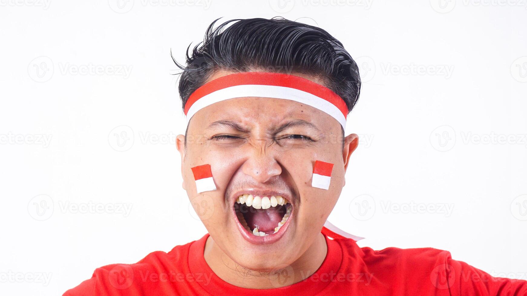 Close up portrait of Indonesian man with red and white attributes celebrate independence day of Indonesia on August 17 isolated on white background photo