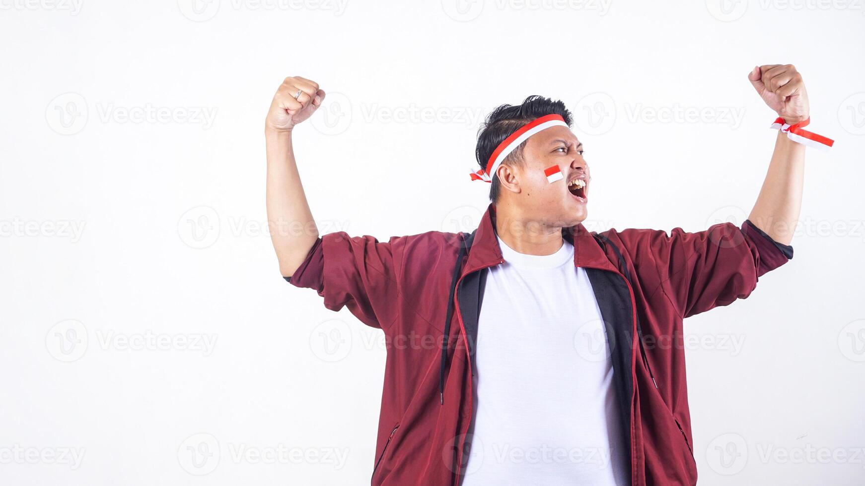 Excited Indonesian man with red and white ribbon wristband to celebrate independence day of Indonesia isolated on white background photo