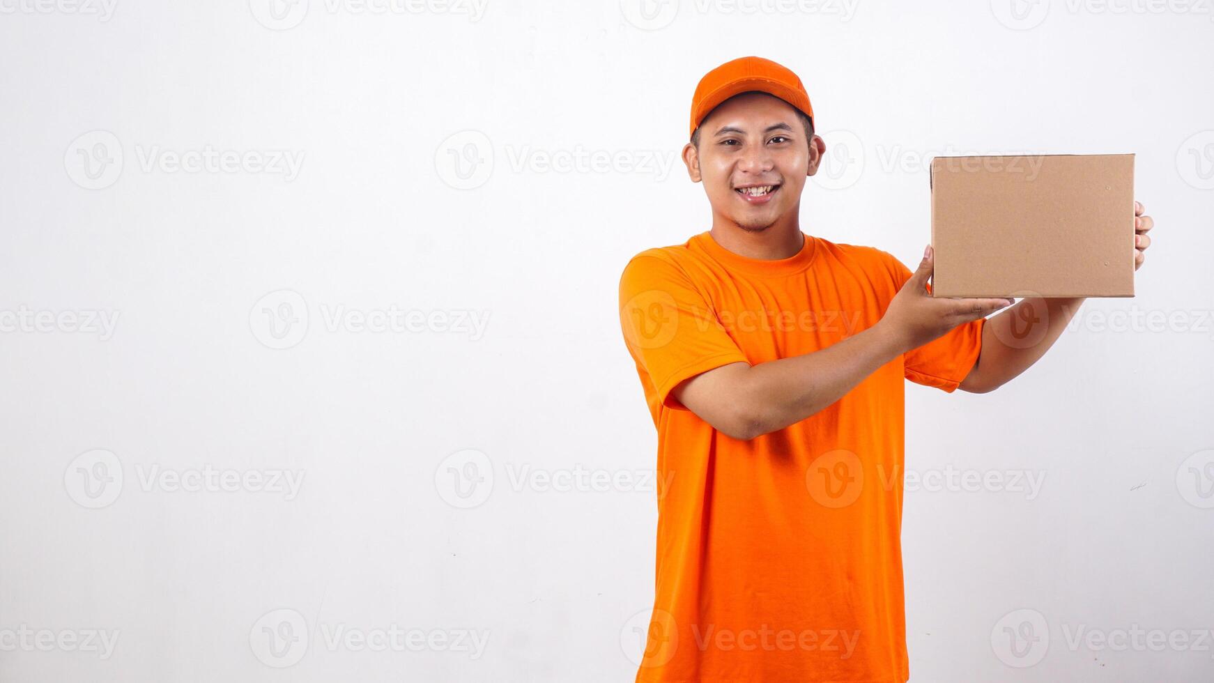 Asian deliveryman in orange t-shirt uniform with a package box parcel isolated on white background photo