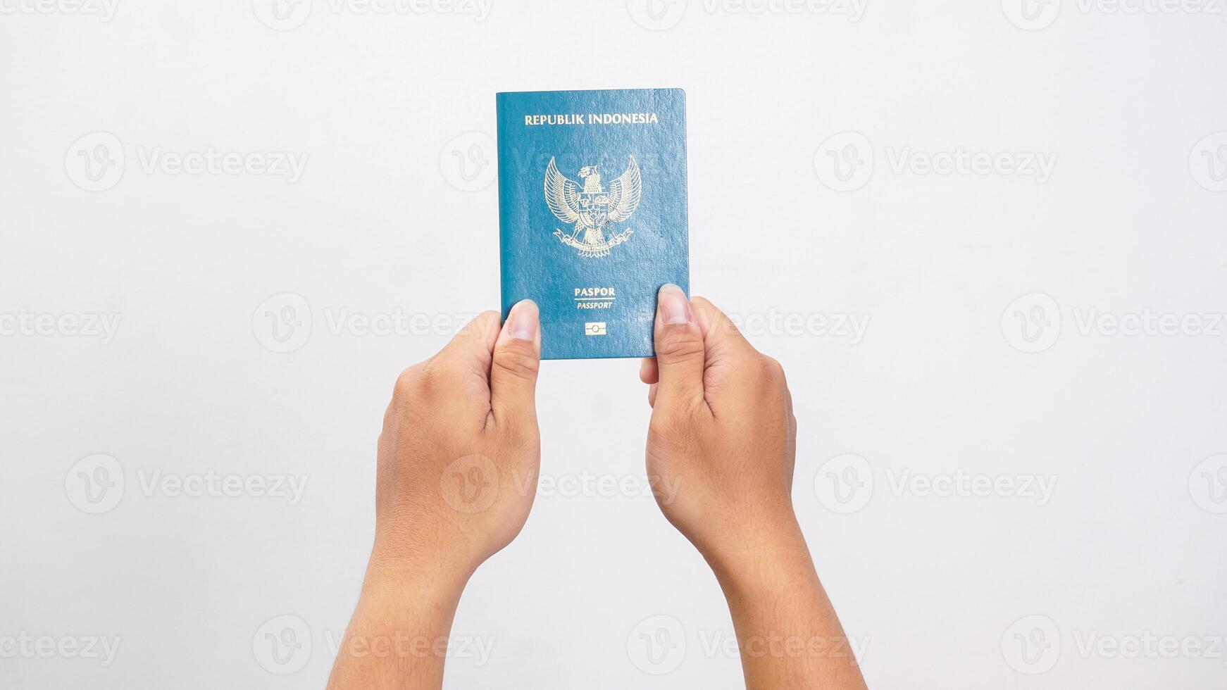 Yogyakarta, Indonesia, 2025 - Man hand holding Indonesian passport document isolated on white background photo