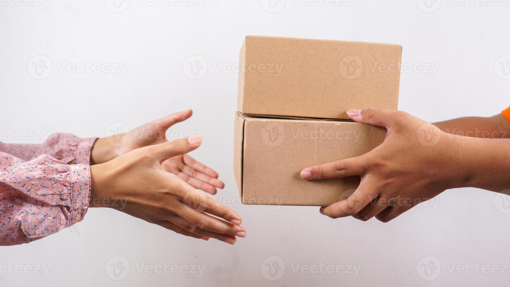Close up of customer taking package boxes parcel delivered by delivery man isolated on white background photo