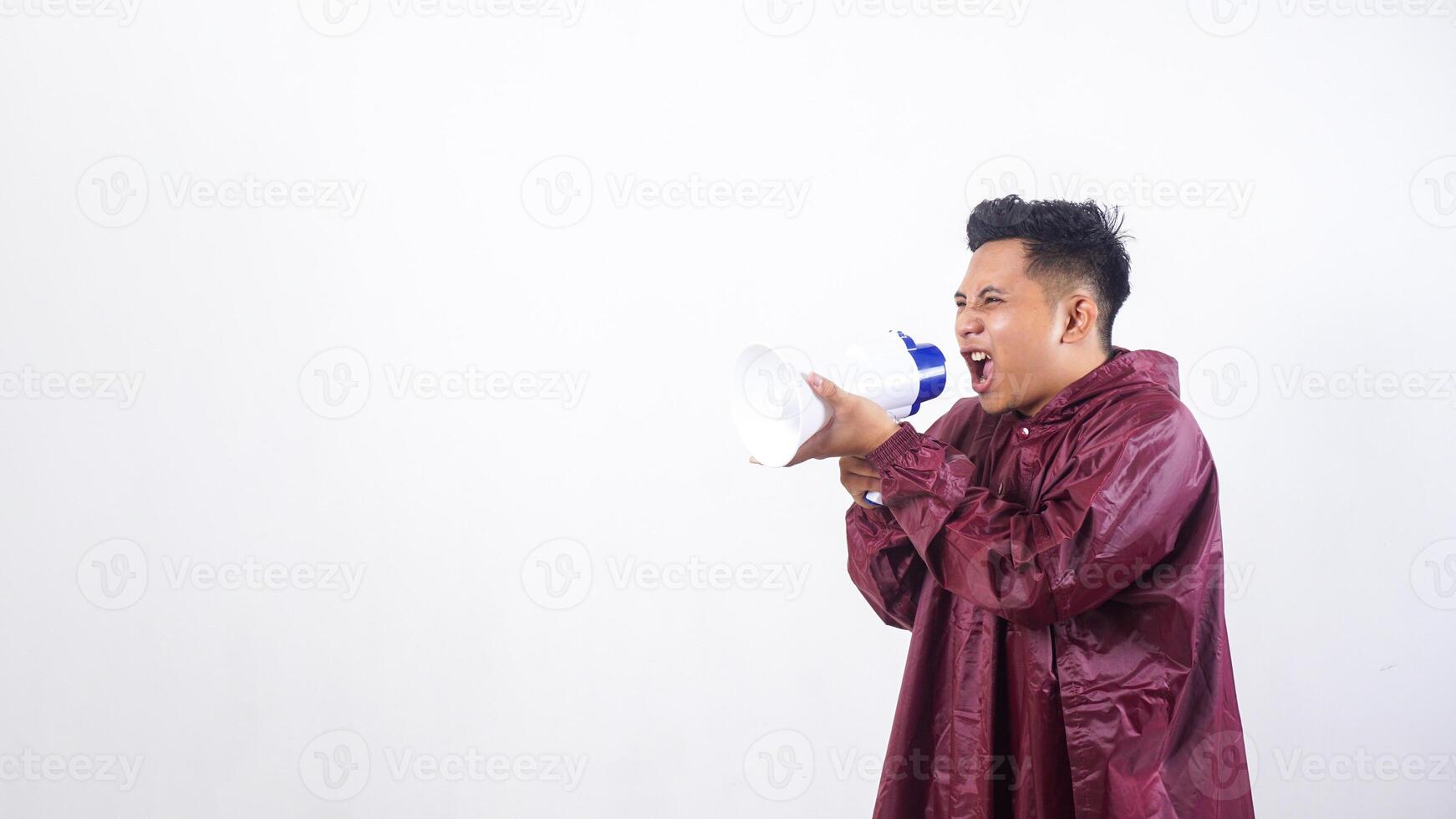 Portrait of Asian man in red raincoat shouting on megaphone isolated on white background photo