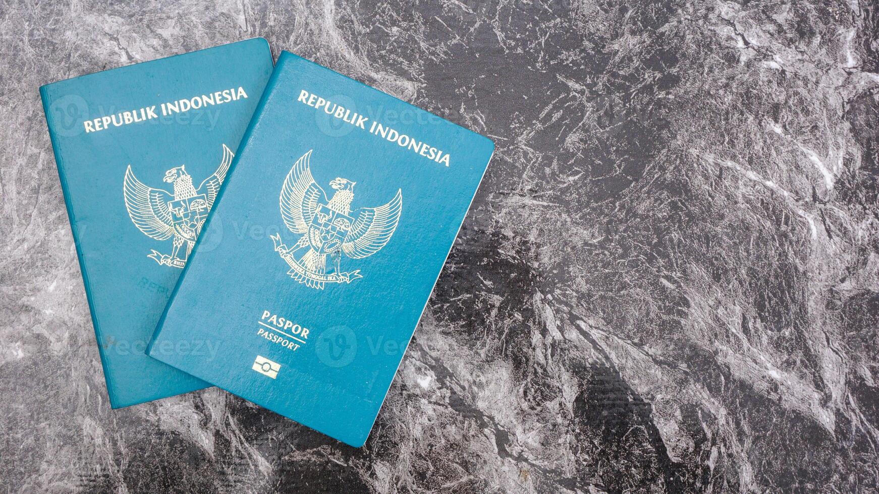 Yogyakarta, Indonesia, 2025 - Indonesian passports isolated on marble pattern background photo