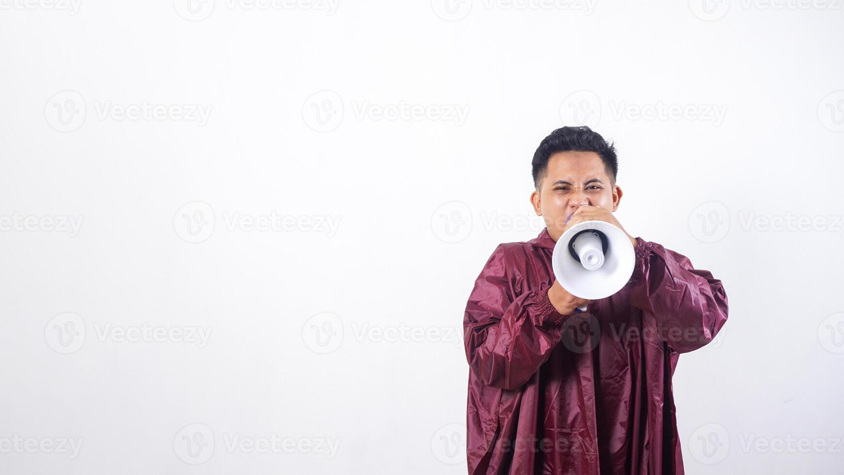 Asian man in red raincoat shouting on megaphone isolated on white background photo