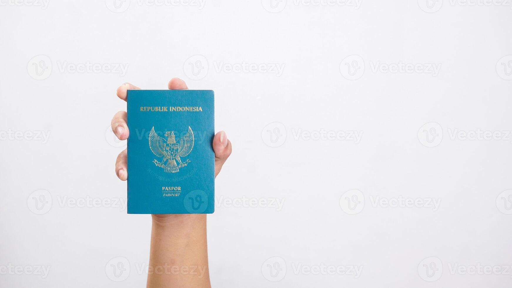 Yogyakarta, Indonesia, 2025 - Man hand showing Indonesian passport isolated on white background photo