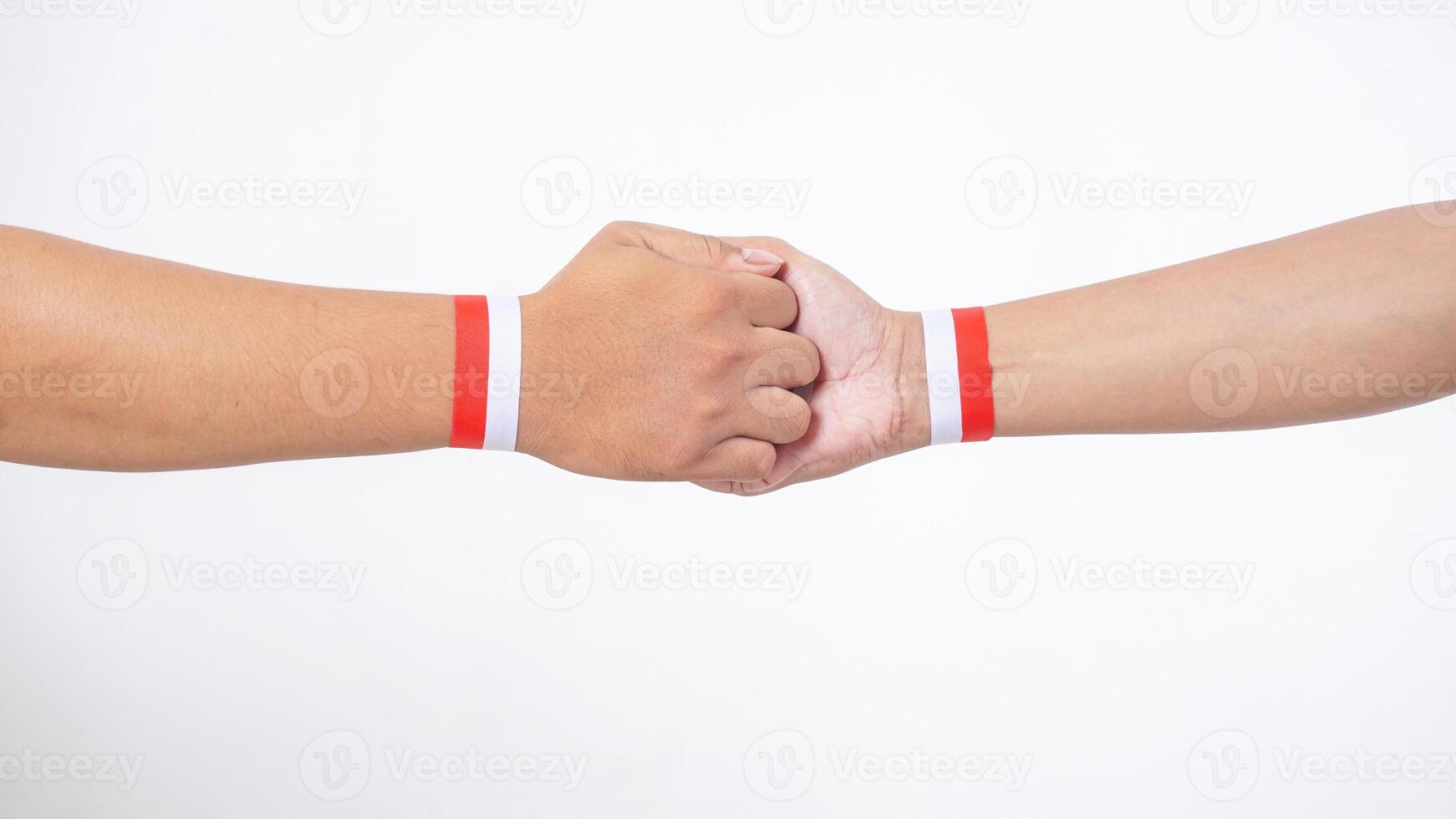 Close up of two men hands with red and white wristband gripping each other isolated on white background photo