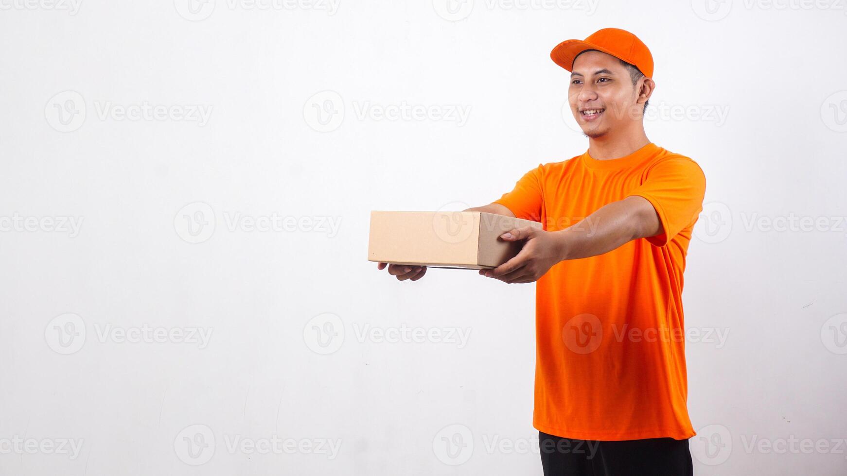 Asian deliveryman in orange t-shirt uniform giving a package box parcel to customer isolated on white background photo