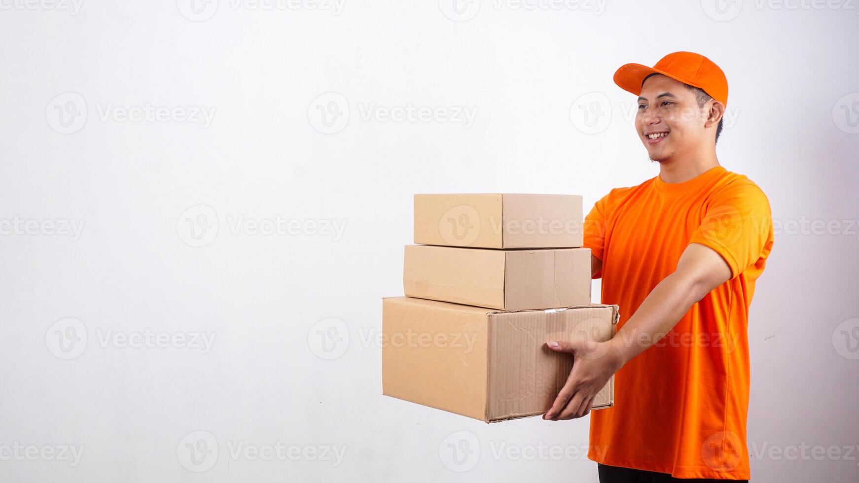 Portrait of Asian deliveryman in orange t-shirt uniform giving stack of package boxes parcel to customer isolated on white background photo