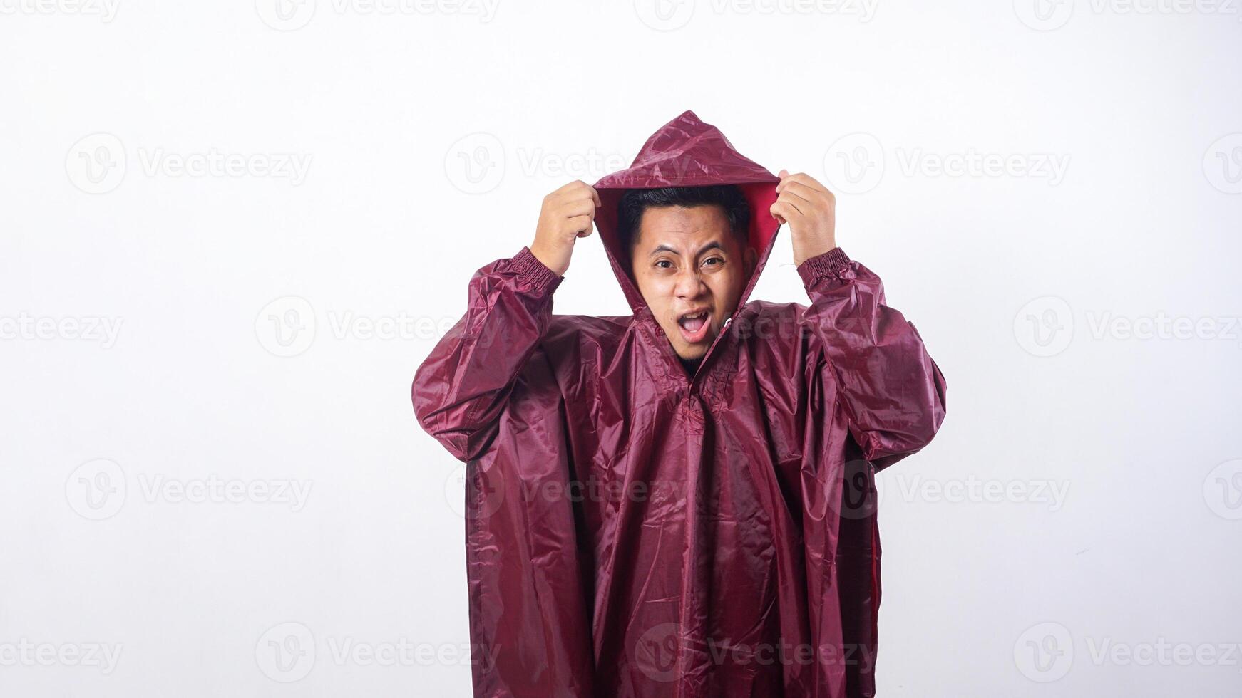 Asian man in red raincoat covering his head from rain with it raincoat hood isolated on white background photo