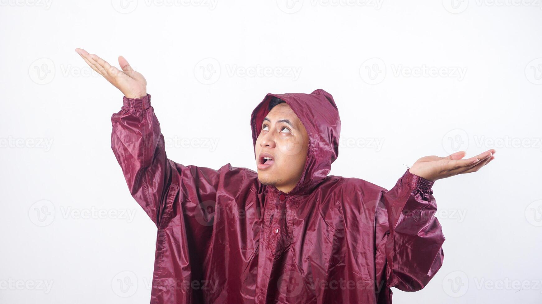 Portrait of Asian man in red raincoat checking if rain stopped isolated on white background photo