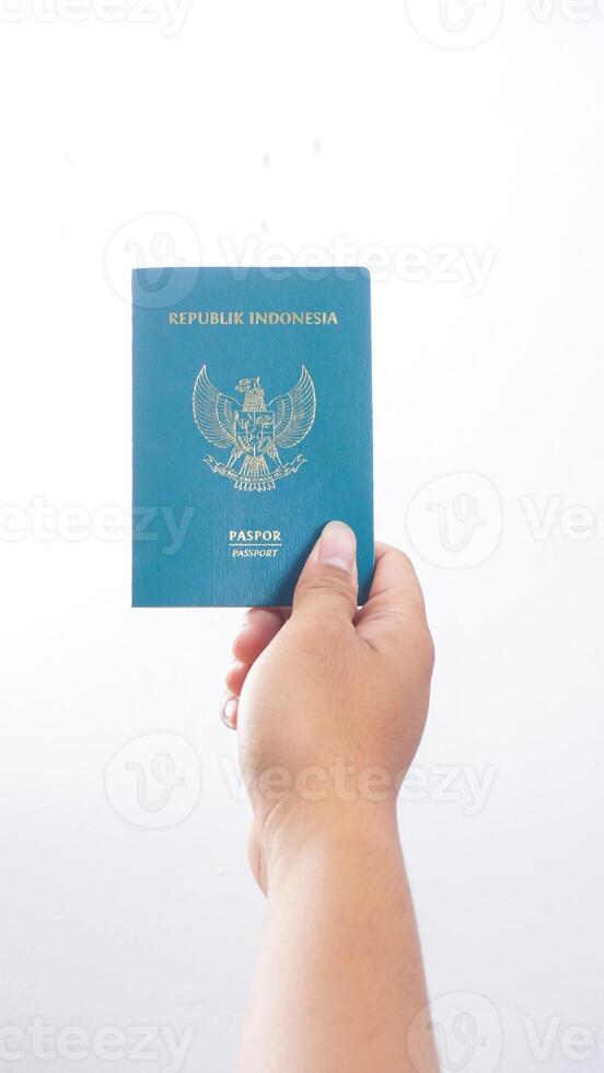 Yogyakarta, Indonesia, 2025 - Hand holds Indonesian passport isolated on white background photo