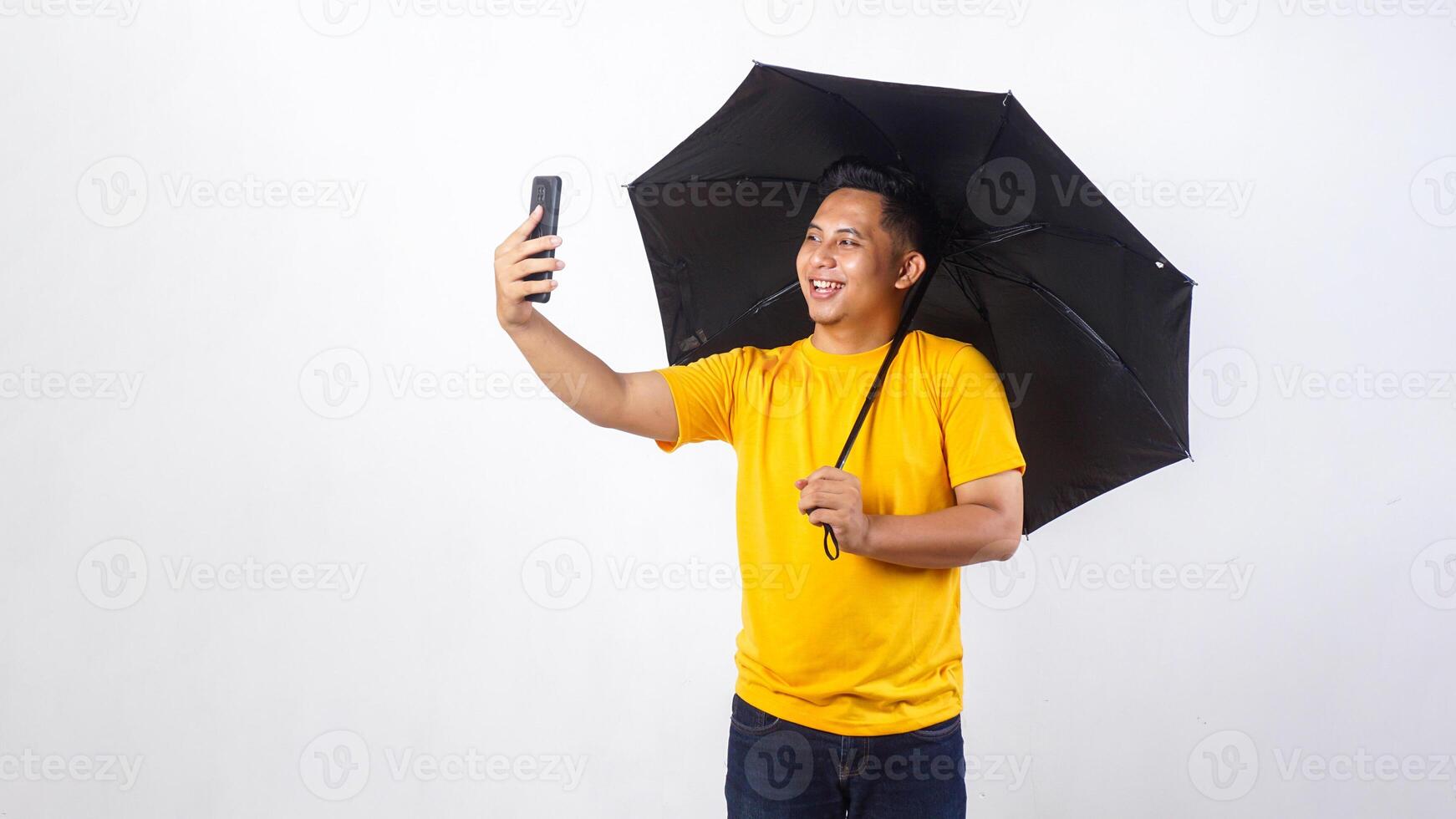 Asian man with an umbrella take a self photo or doing call with phone isolated on white background