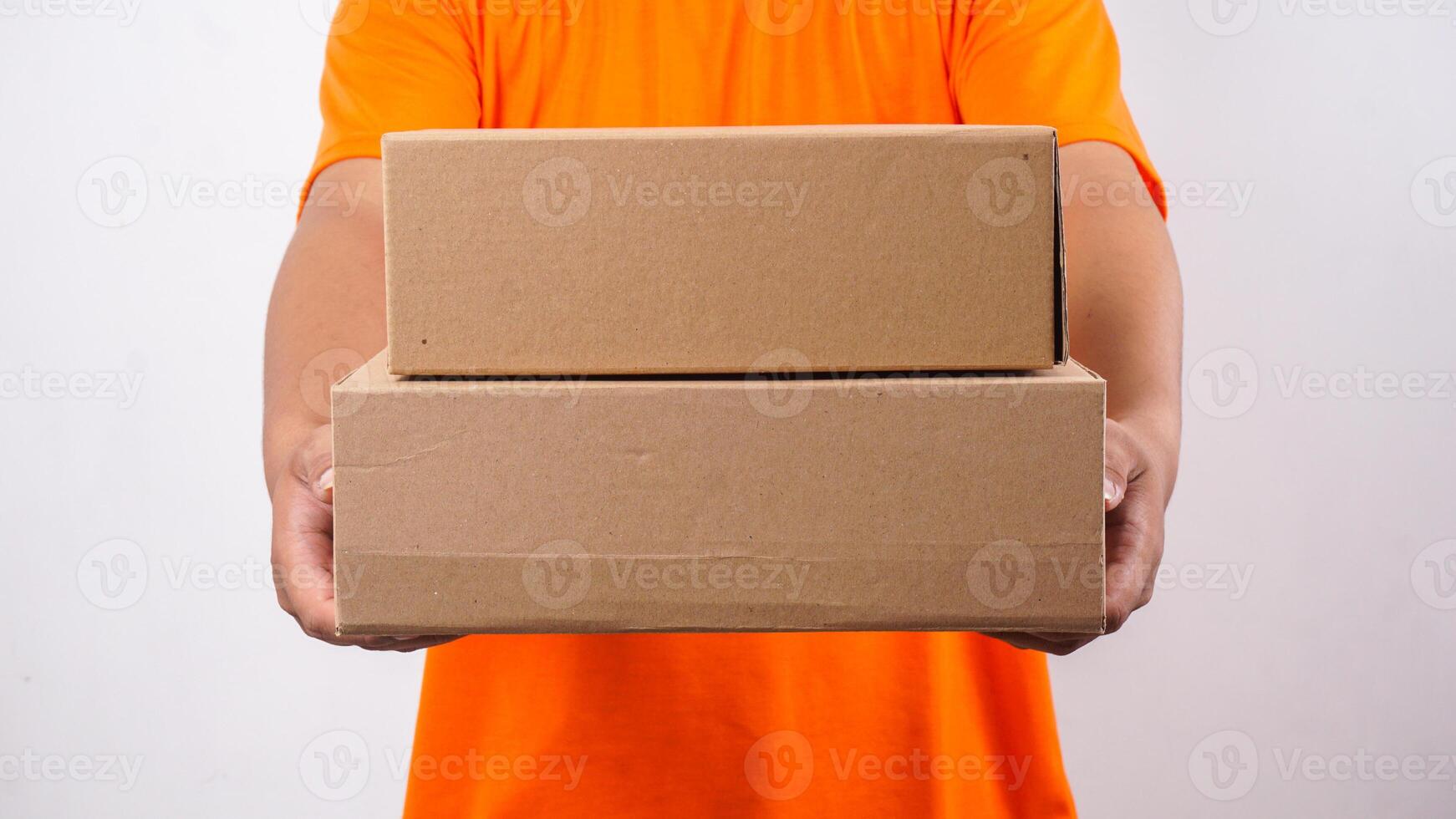 Close up of delivery man in orange t-shirt giving package boxes parcel to customer isolated on white background photo