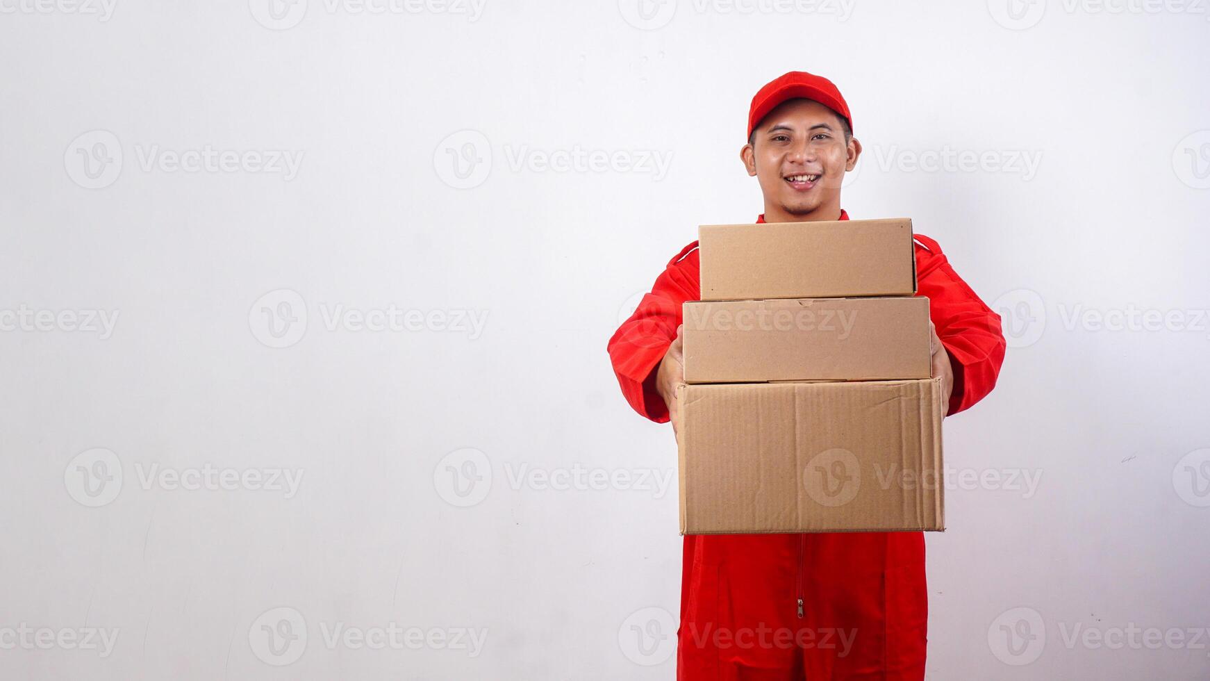 Asian Delivery man in red uniform holding package boxes parcel isolated on white background photo