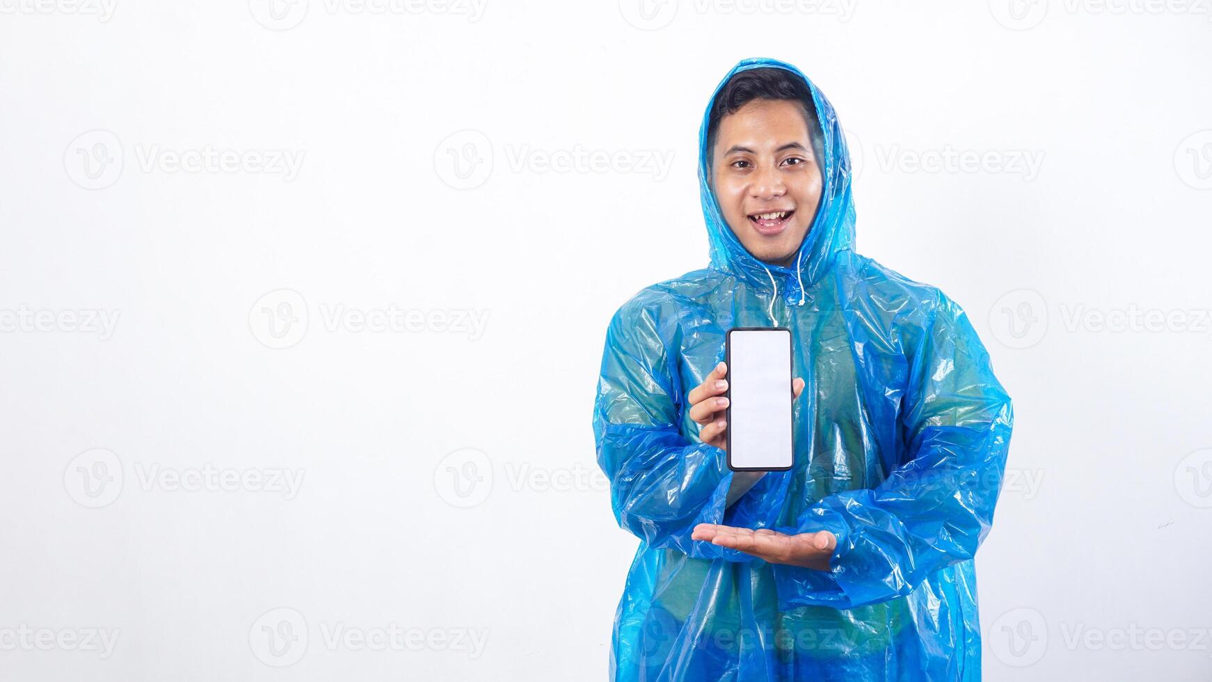 Asian young man in blue raincoat presenting smartphone mock up with blank screen isolated on white background photo