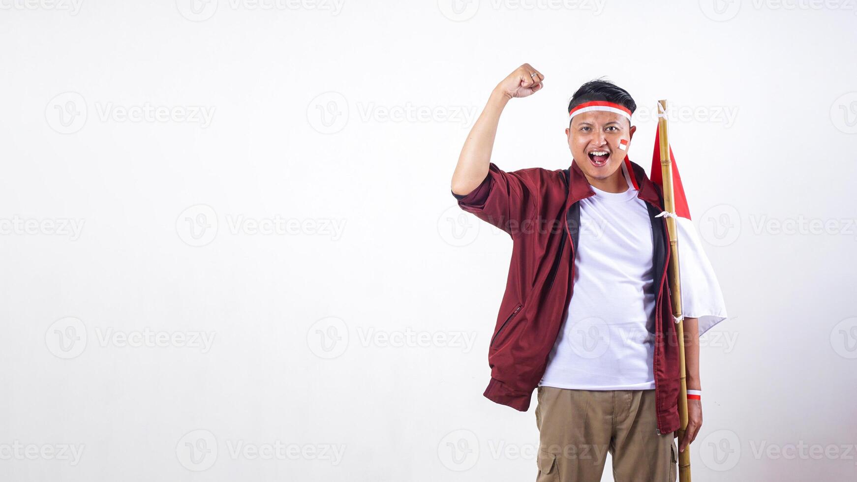 Indonesian man holding stick with red and white flag of Indonesia isolated on white background photo