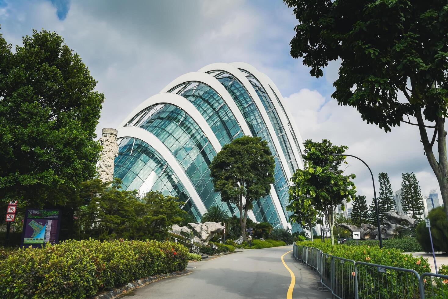 Singapore, Singapore - 4 April 2025 Futuristic Cloud Forest greenhouse at Gardens by the Bay with glass arches and lush greenery under a tropical sky photo
