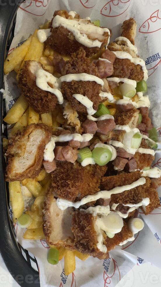 Fries Topped with Fried Chicken, Ham, and Sauce photo