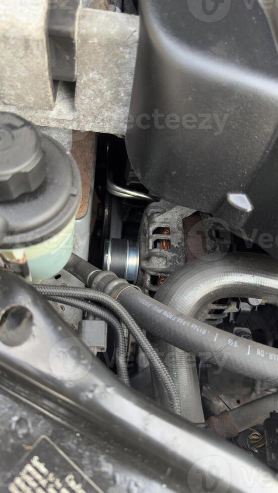 Automobile Engine Compartment Close-Up with Alternator and Hoses photo