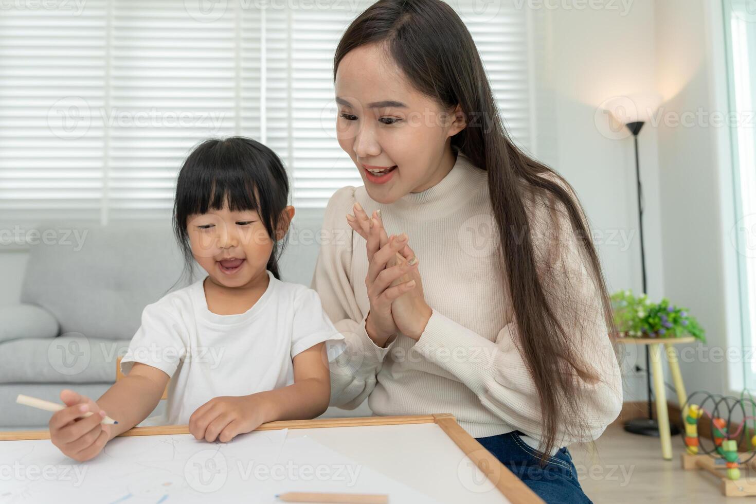 Happy Asia mother learning paint for little girl. family is happy and excited in the house. Mother and daughter having fun spending time together. Holiday, Activity, Executive Function, IQ photo