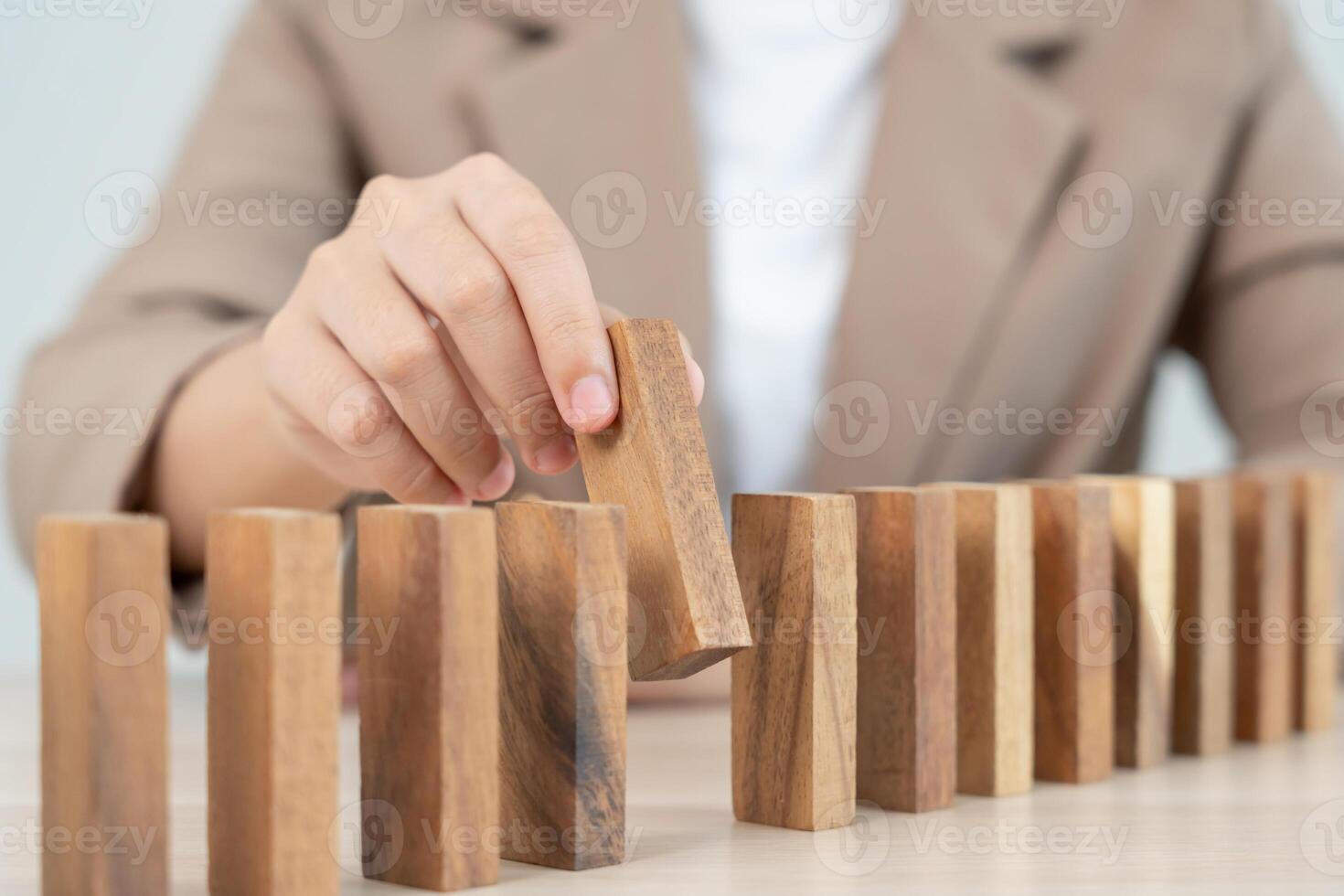 hands protect domino. Businessman hands stop dominoes falling in house crisis. business risk control and planning and strategies to run prevent insurance businesses. photo