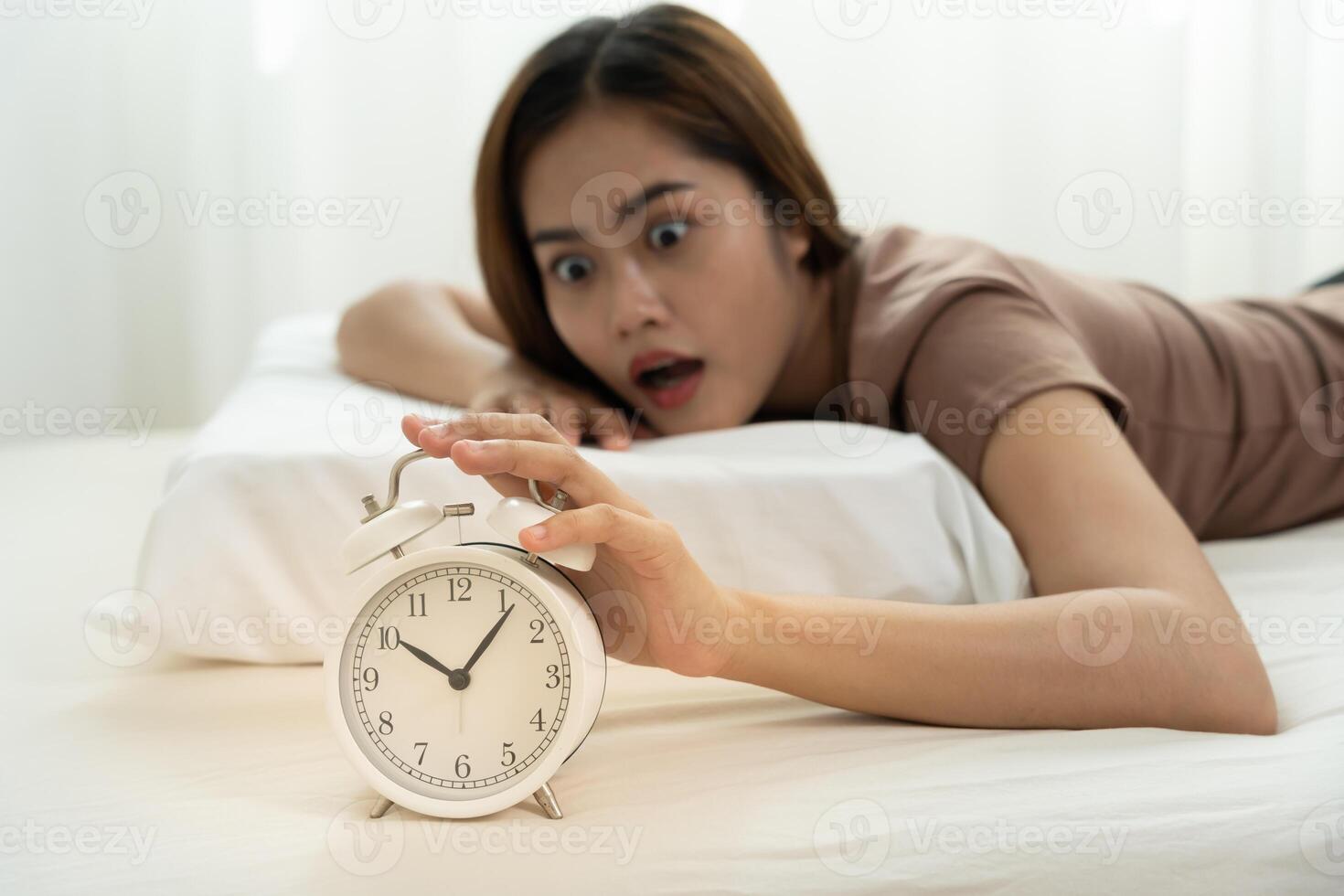 Shocked Asia woman looking at clock alarm, lady is late appointment or work or class study, overslept, difficulty get up in mornings, time worried, not on time, sleepy, over due, Hurry up time photo