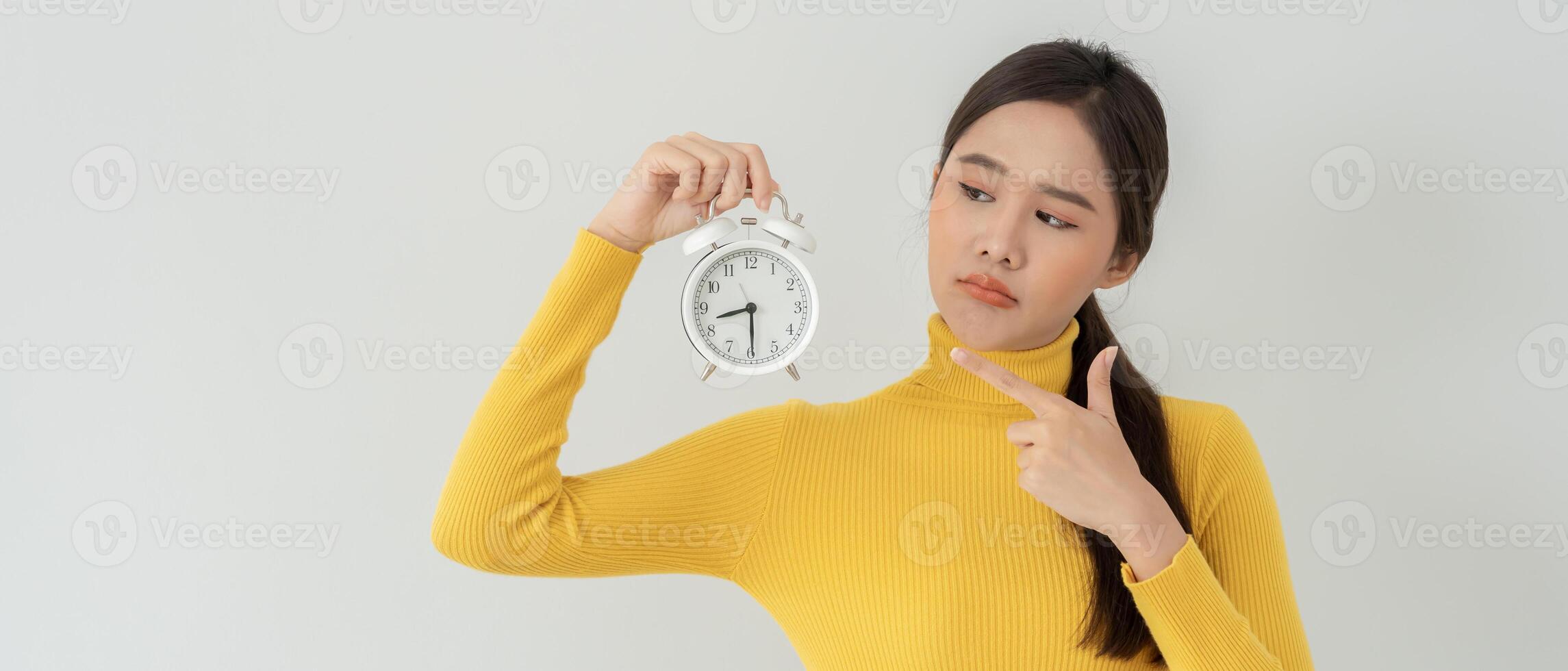 Asia young woman show clock alarm, lady is late appointment or work or class study, overslept, difficulty get up in mornings, time worried, not on time, sleepy, over due, Hurry up time photo