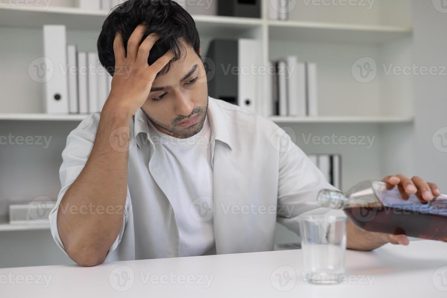 Depressed young business man addicted feeling bad drinking whiskey alone at home, stressed frustrated lonely drinking alcohol suffers from problematic liquor, alcoholism photo