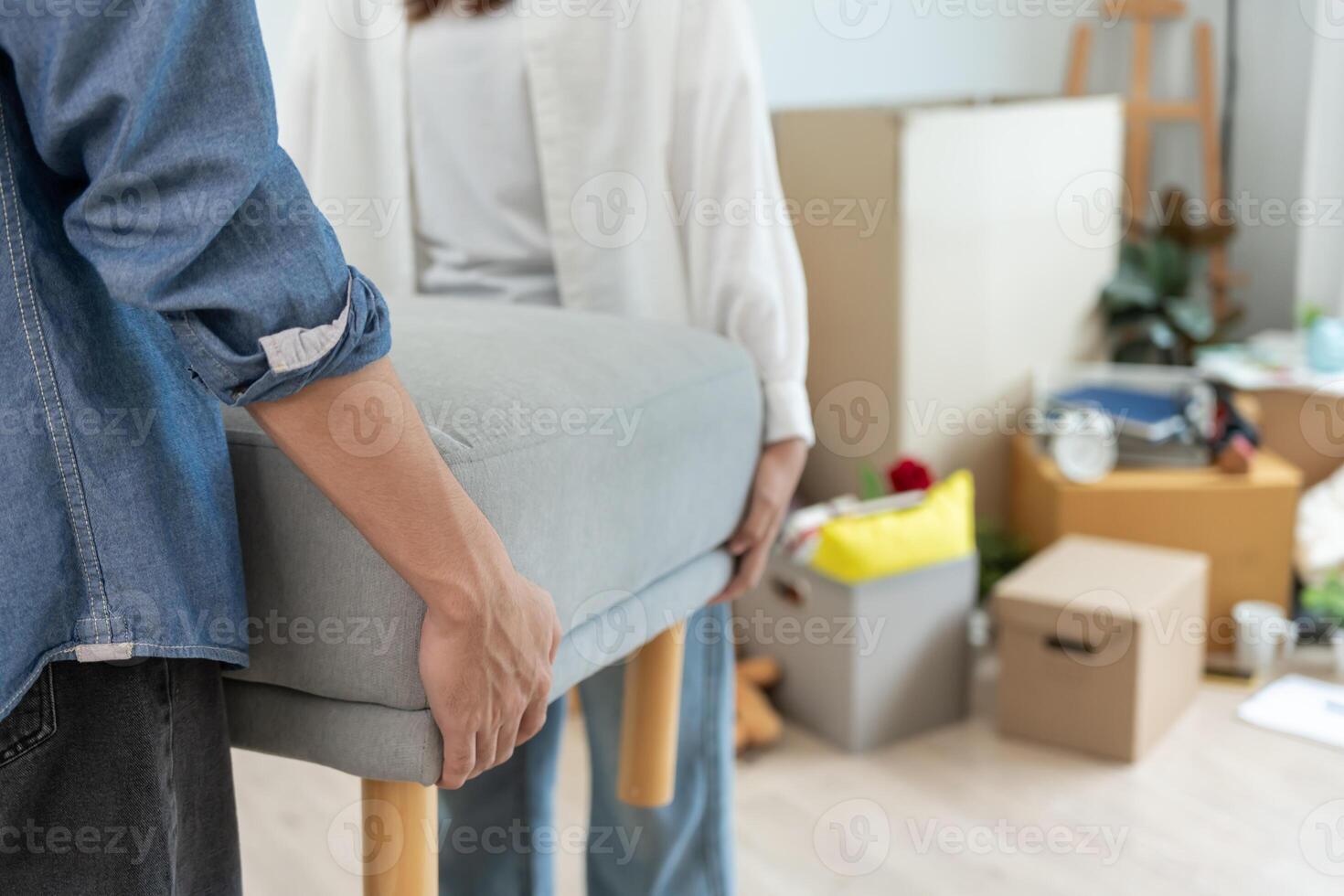 Moving house, relocation. Couple help set sofa and move furniture for new apartment, inside the room was a cardboard box contain personal belongings. move in the new apartment or condominium photo