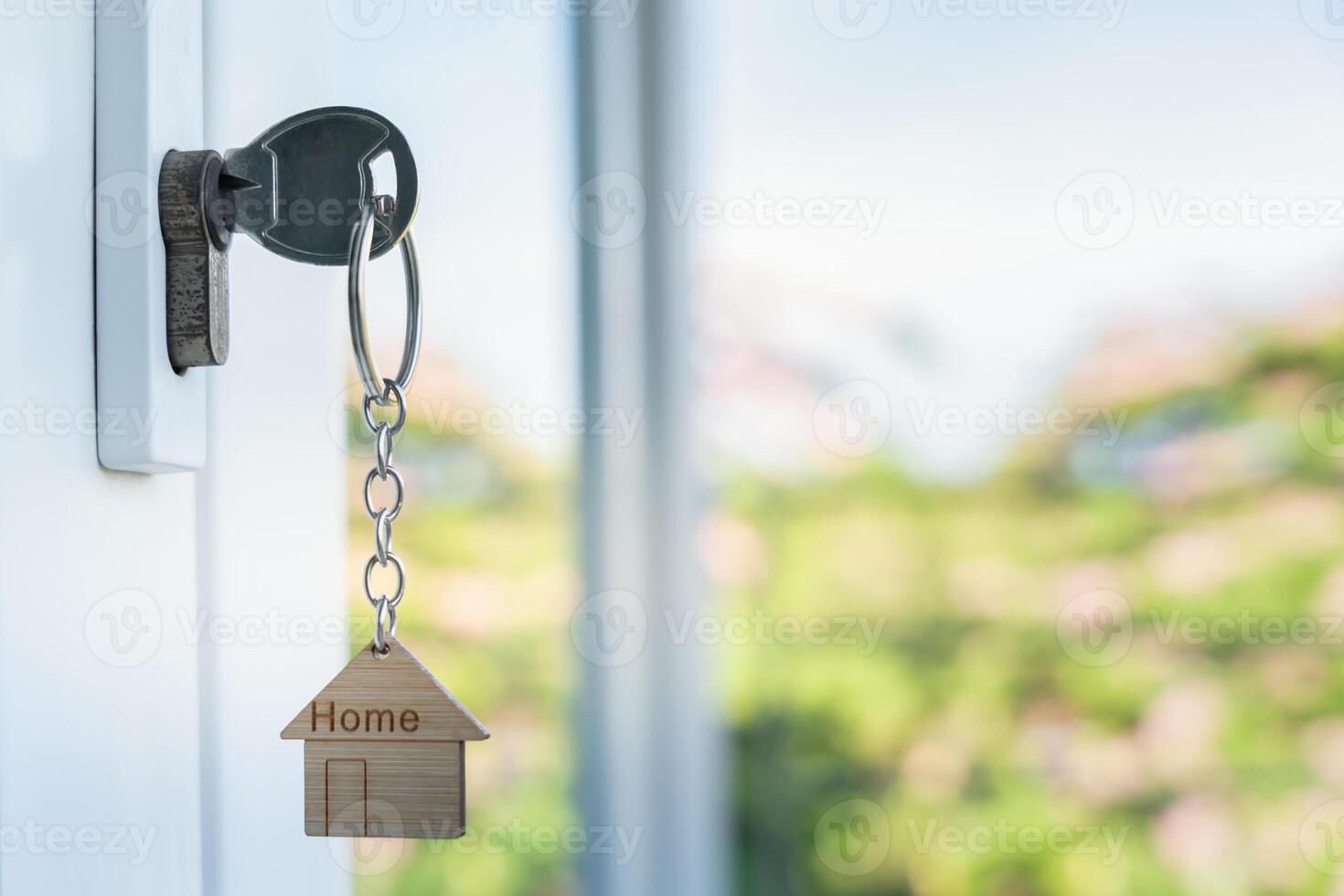 unlocking house is plugged into the door. Second hand house for rent and sale. keychain is blowing in the wind. mortgage for new home, buy, sell, renovate, investment, photo