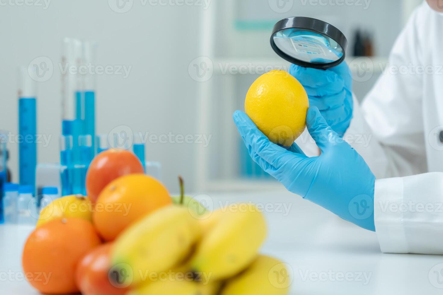 use magnifying glass to check physical occur from chemical on fruit and vegetable residues in laboratory. inspect the concentration of chemical residues, standard, find prohibited substances photo