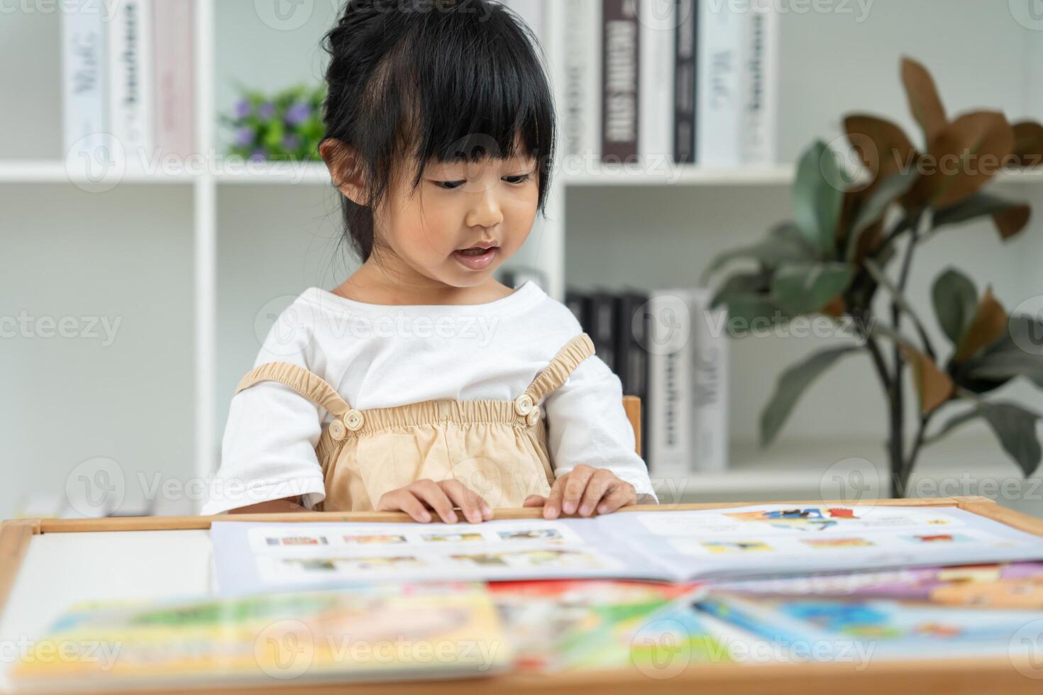 Happy Asian children relax read book at home. daughter and reading a story. learn development, childcare, laughing, education, storytelling, practice, imagine, reduce addiction mobile photo