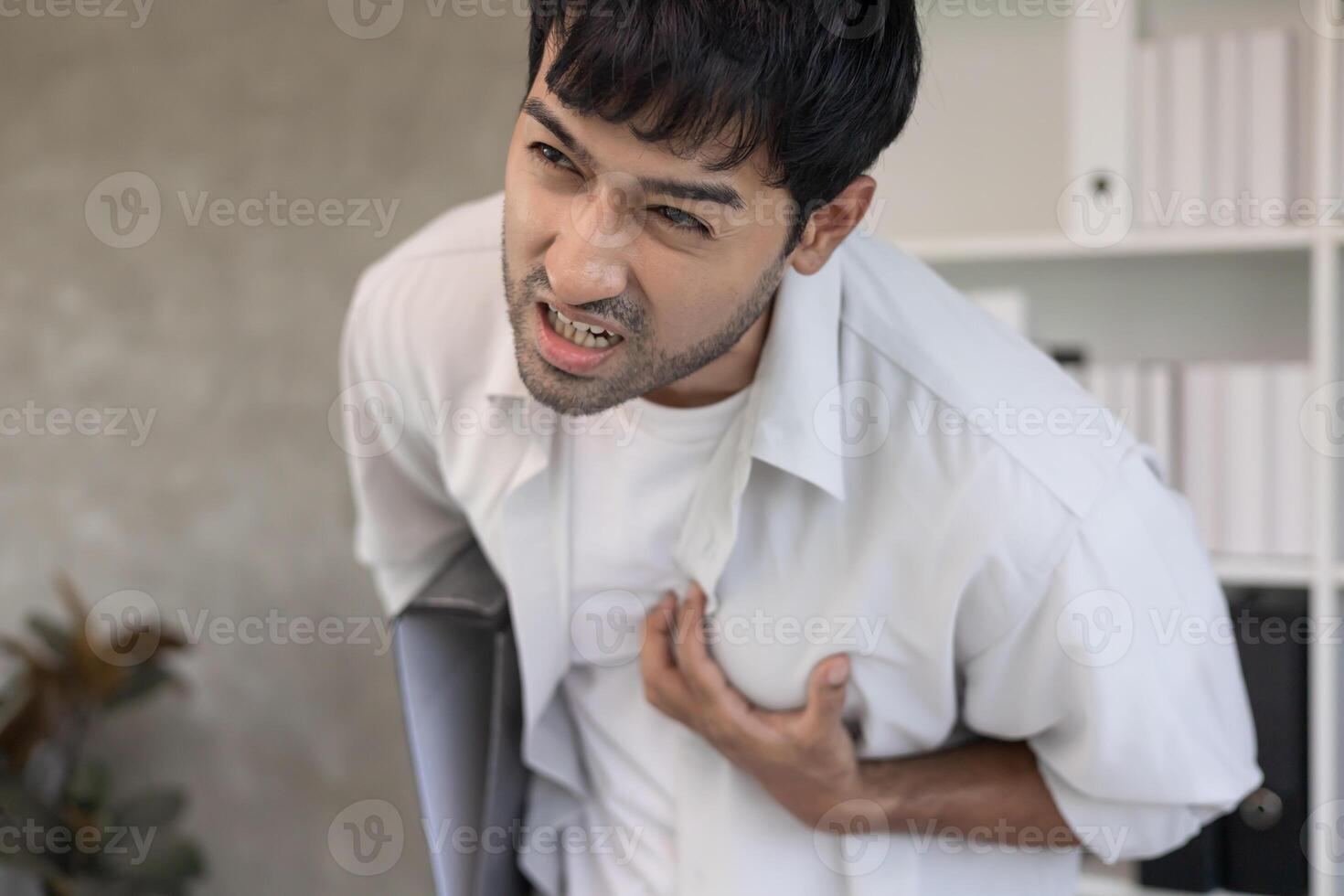 hand hold chest with heart attack symptoms, asian man have chest pain caused by heart disease, leak, dilatation, enlarged coronary heart, press on the chest with a painful photo