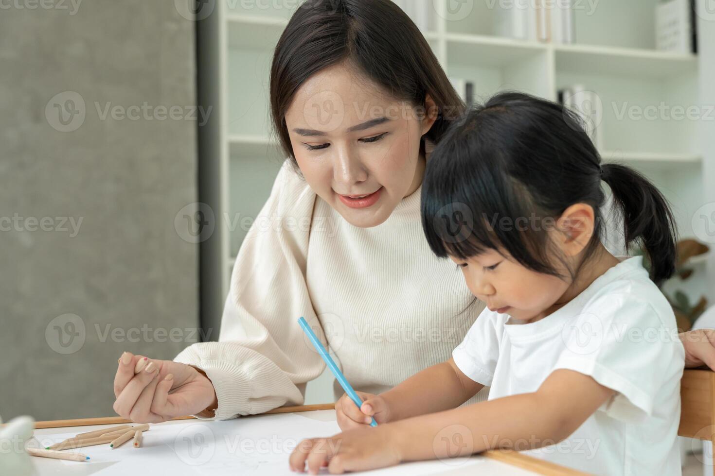 Happy Asian mother playing learning paint for little girl. Funny family is happy and excited in the house. Mother and daughter having fun spending time together. Holiday, Activity photo