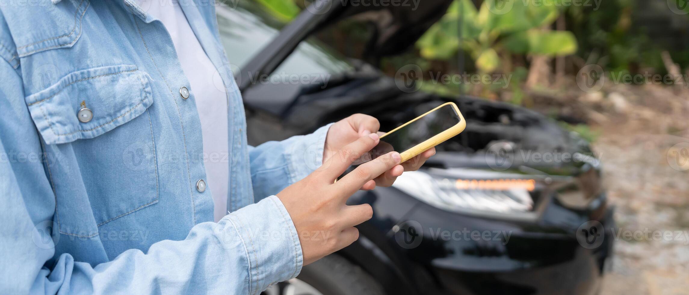 breakdown, broken car, repair, Woman uses mobile phone check insurance premiums through application due to car accident . Find garage to get car fixed during country tour, waiting for help, emergency. photo